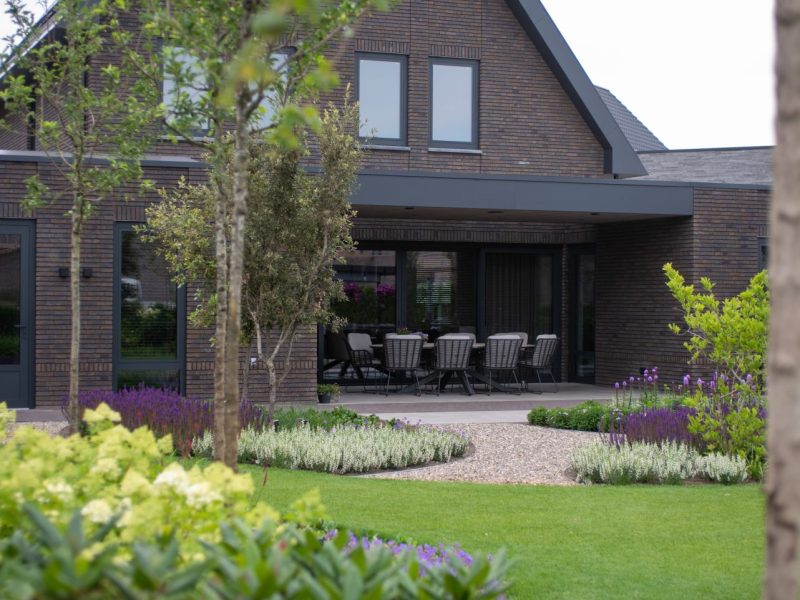 Deze tuin is een buitenruimte waarin elegantie, rust en luxe centraal staan. De tuin kenmerkt zich door organische vormen. Veel groen zoals siergrassen, meerstammige heesters en bomen, geven de tuin een weelderige uitstraling die elk seizoen leeft.